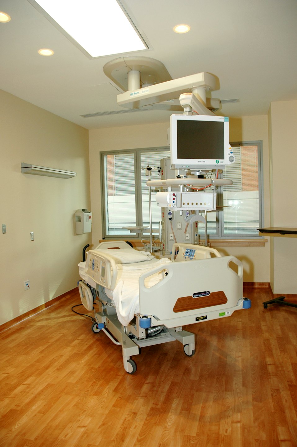 Empty hospital room with a modern bed and medical equipment.